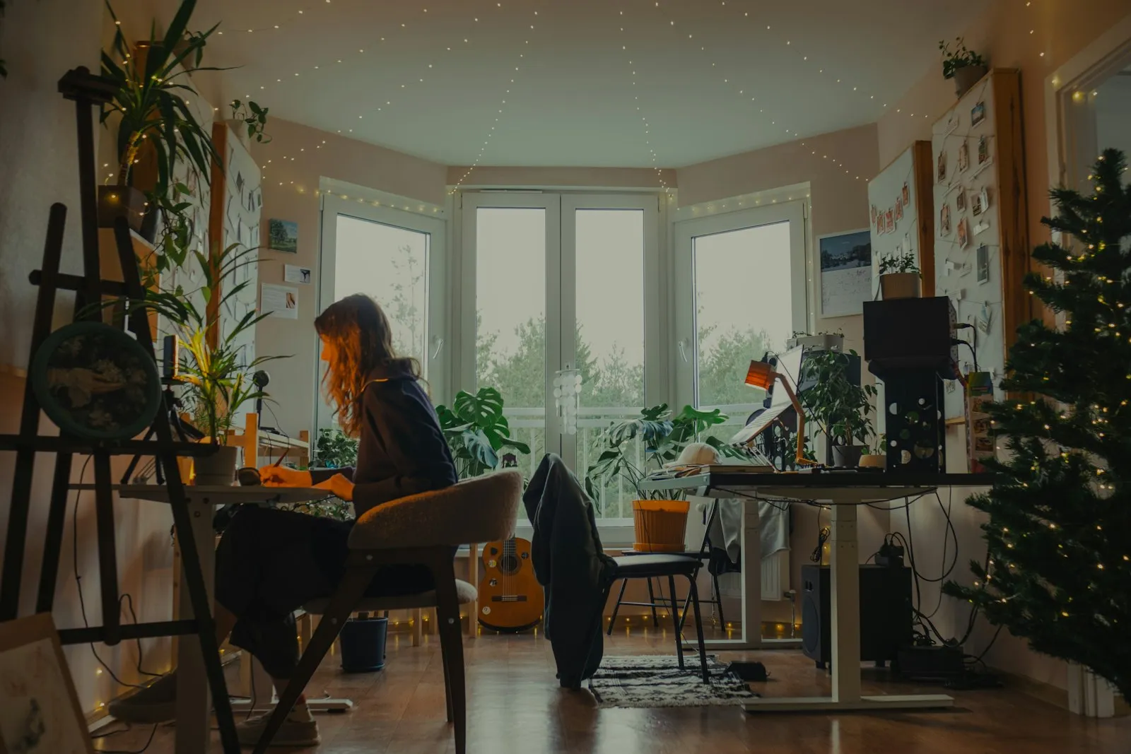 A person working at a desk in a plant-filled room